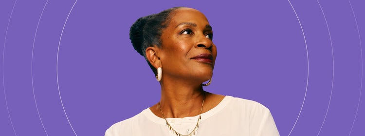 Photo of a mature African-American woman with COVID-19 high-risk factors, smiling and looking into the distance.