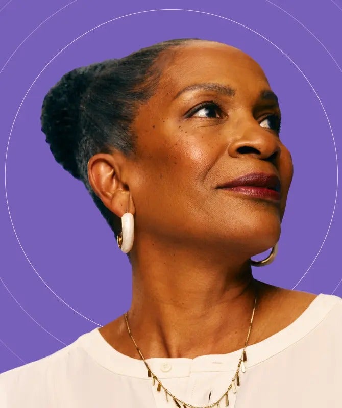 Photo of a mature African-American woman with COVID-19 high-risk factors, smiling and looking into the distance.